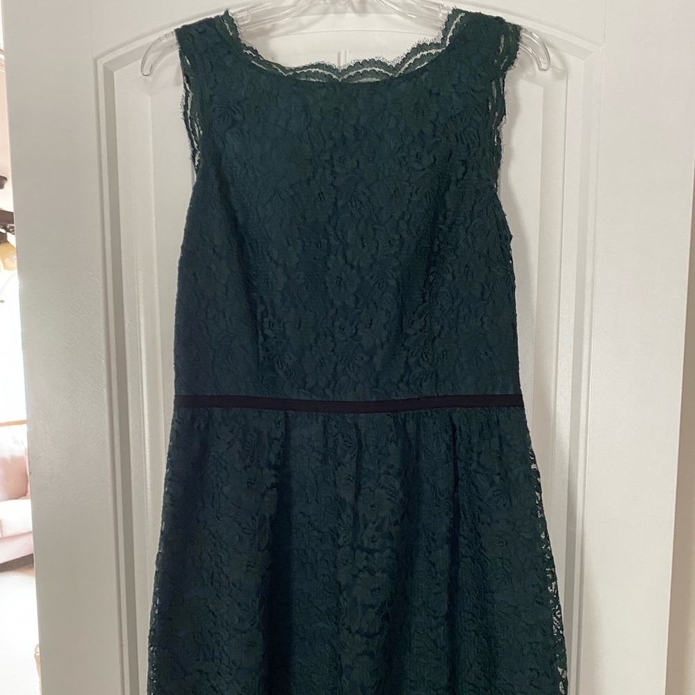 Emerald green lace dress with black waste band. V-neck back with zipper. Size 8.